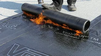 Eine Vedag Bitumenbahn wird verschweißt.