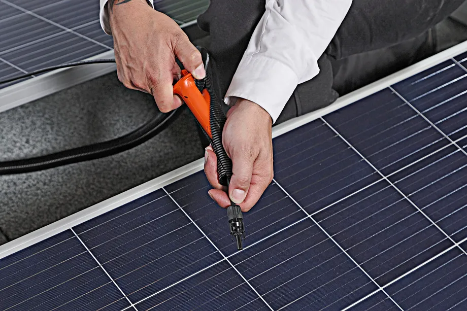 Die Kabeldurchführung beim Modul einer Solaranlage für das Flachdach mit Hilfe eines Werkzeugs.